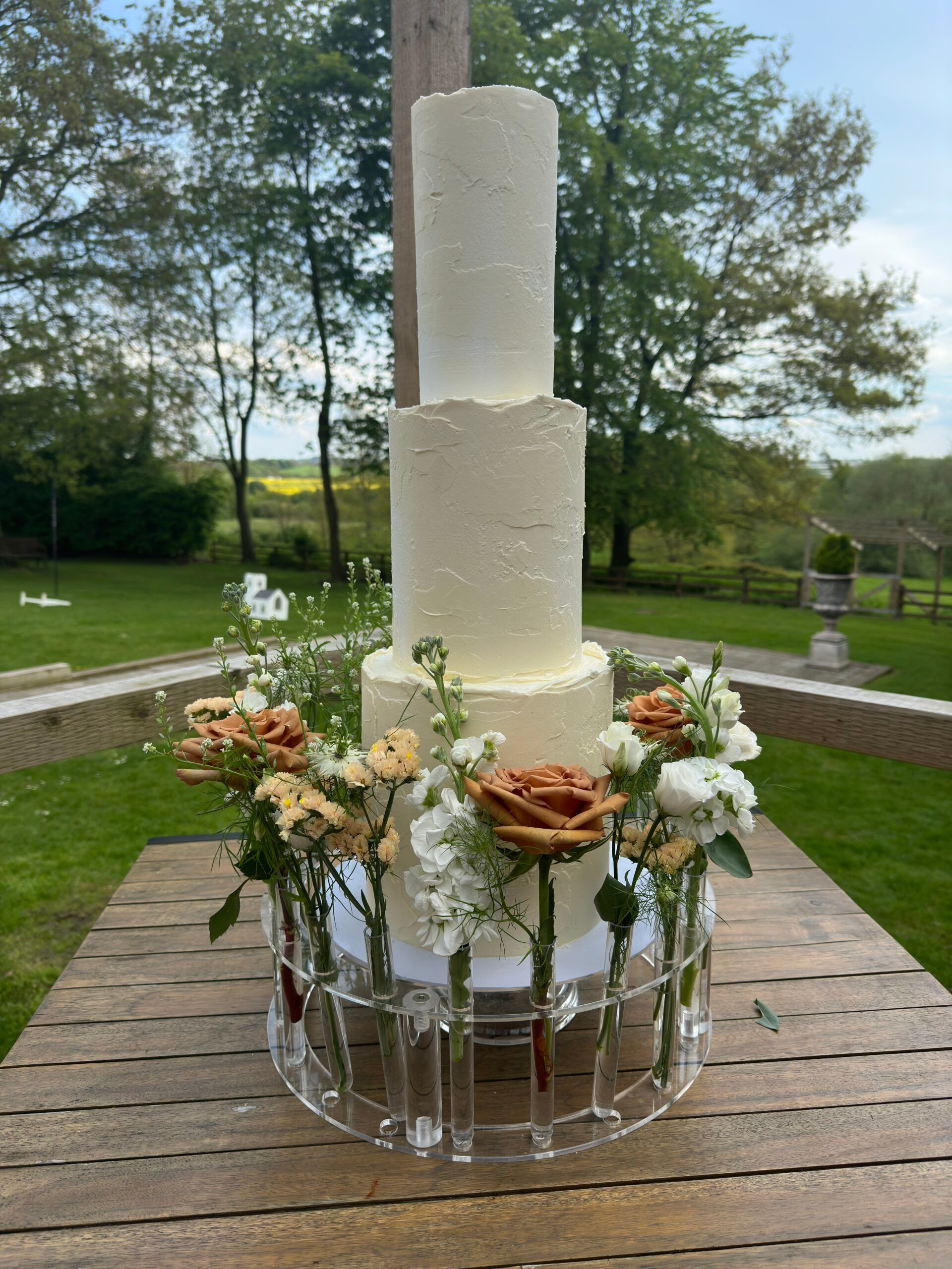 Soft buttercream wedding cake dressed with delicate blooms